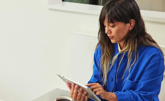 Junge Frau mit Tablet am Tisch